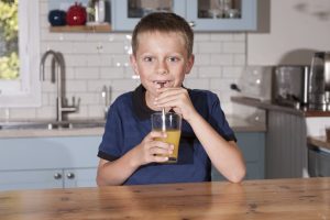 Boy drinking juice through metal straw